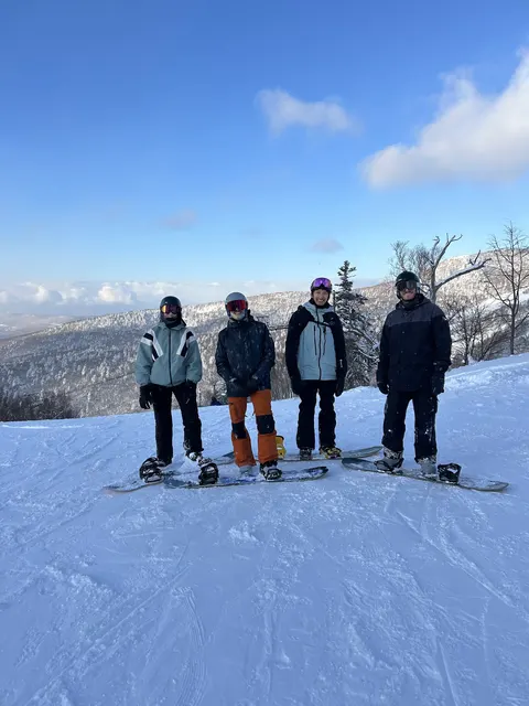 Four friends on the slope under a blue sky