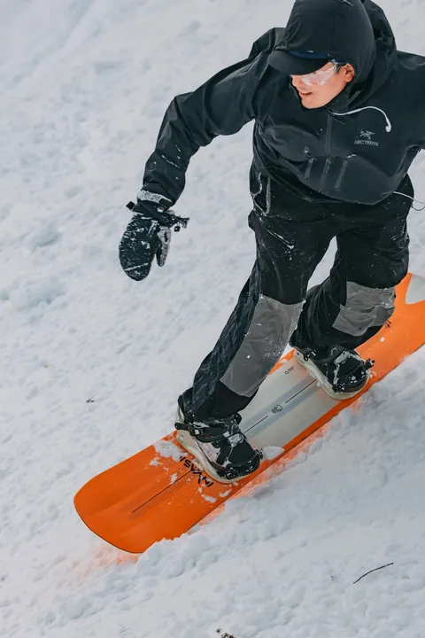 Snowboarder carving on an orange board