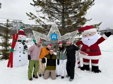 Group posing with a Santa statue on the slope