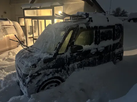 Car buried in snow at night
