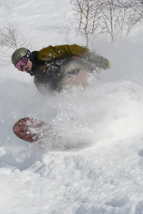 Snowboarder buried in a powder spray