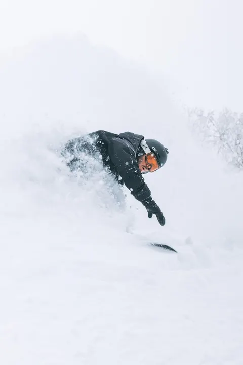 Snowboarder disappearing into a powder spray