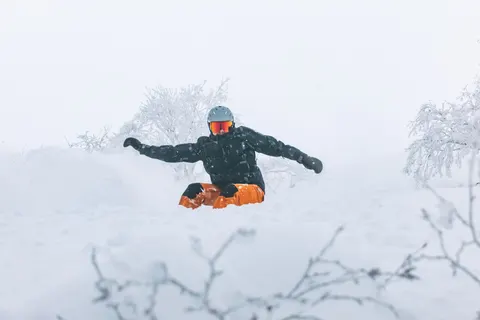 Snowboarder with arms out in deep powder