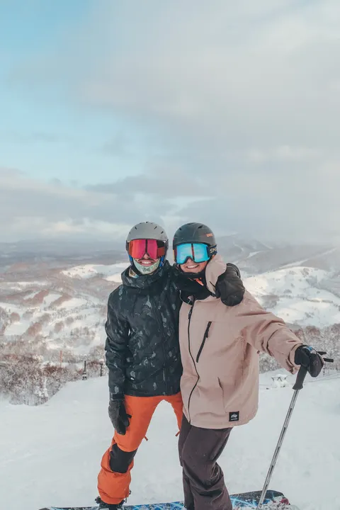 Two friends on the slope with mountain views