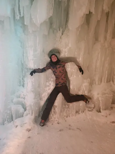 Housemate posing against a wall of ice at night