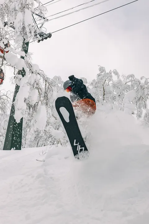 Snowboarder dropping off a snow pillow