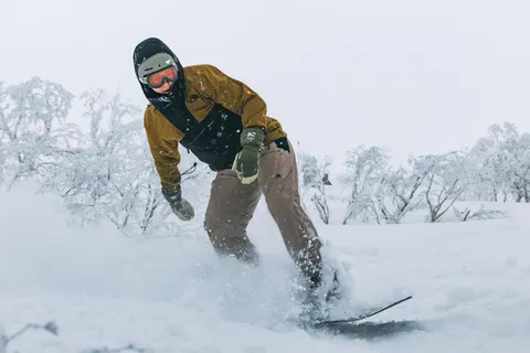 Snowboarder turning through deep powder