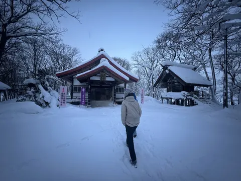 Walking to a snowy shrine at dusk