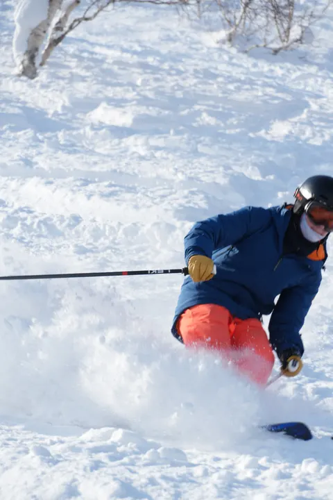 Skier throwing a powder spray