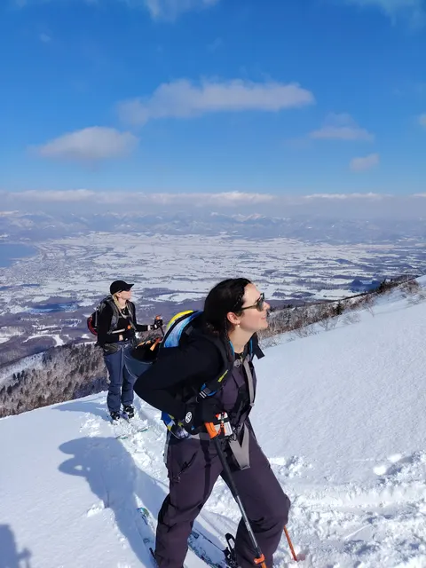 Smiling skier on a ridge above the sea