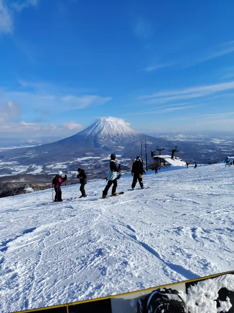 Skiers on a slope with Mt Yotei behind